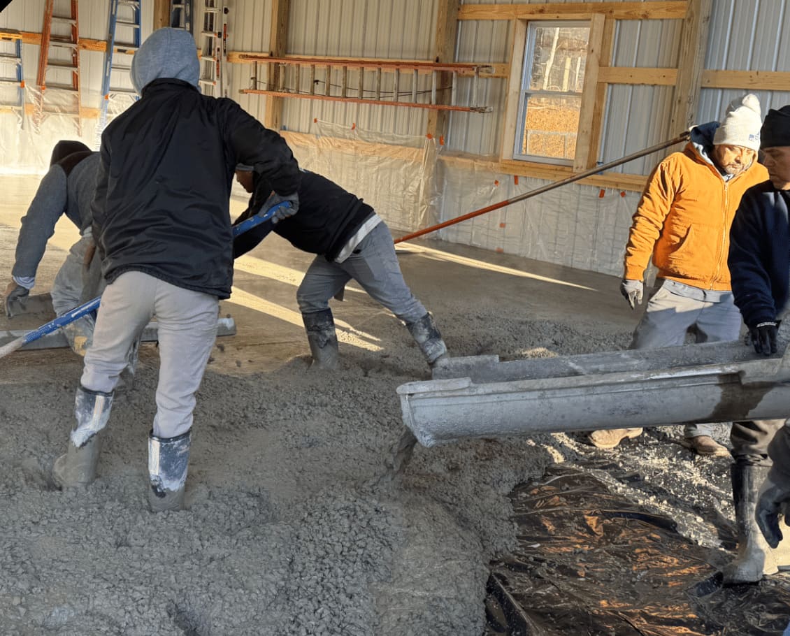 Son Concrete crew placing concrete inside a steel building